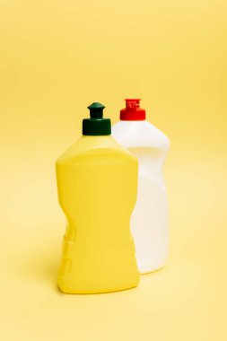 Sarı arka planda bulaşık deterjanı şişeleri