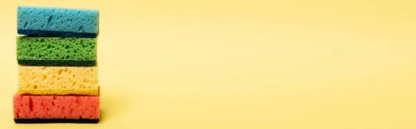 黄色の背景にカラフルなスポンジのクローズアップビュー バナー — ストック写真