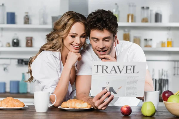 Smiling Couple Reading Travel Newspaper Coffee Croissants Apples Table — Stock Photo, Image
