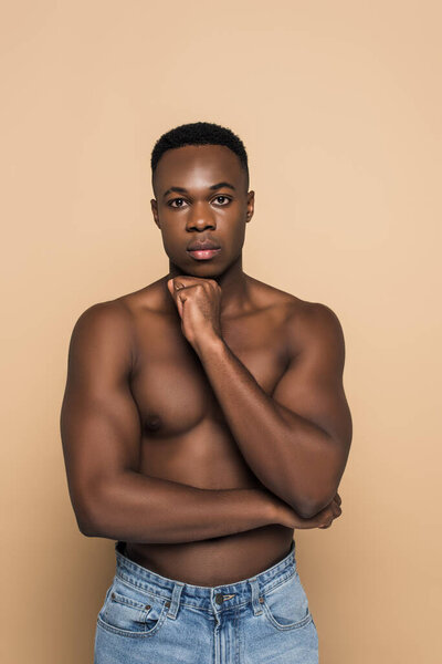 Shirtless african american man looking at camera isolated on beige