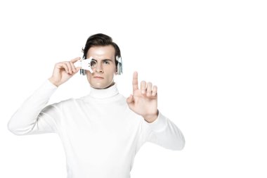 Kulaklıklı ve dijital gözlüklü Cyborg beyaz bir şeye dokunuyor.