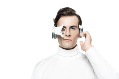 Cyborg in digital eye lens touching headphones and looking at camera isolated on white clipart