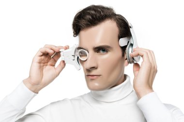 Cyborg kameraya bakarken dijital göz lensi ve kulaklıklara dokunuyor.