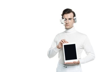 Dijital gözlüklü ve kulaklıklı Cyborg adam beyaz ekranlı dijital tableti gösteriyor.