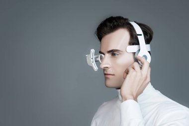 Göz merceği ve kulaklık takmış Cyborg griye bakıyor.