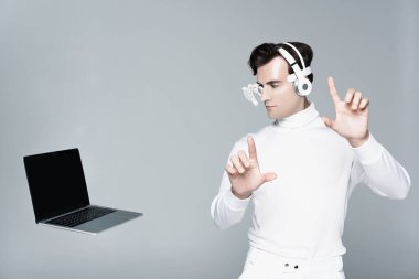 Kulaklıklı Cyborg bir şeye dokunuyor ve gri ekranda boş ekranla bilgisayara bakıyor.