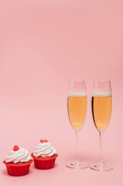 Pembeye izole edilmiş kekler yanında şampanya bardakları.