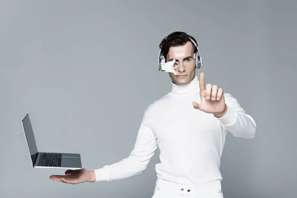 Cyborg Auriculares Tocando Algo Cerca Computadora Portátil Con Pantalla Blanco — Foto de Stock