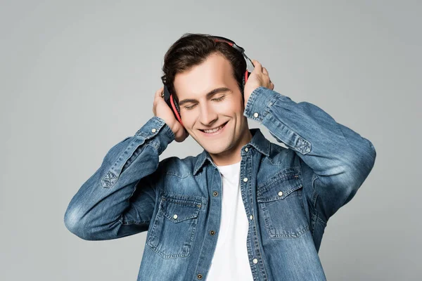 Joven Escuchando Música Auriculares Con Los Ojos Cerrados Aislados Gris —  Fotos de Stock