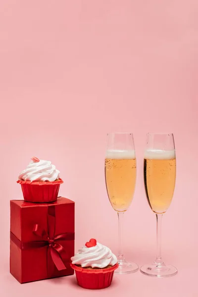 Sektgläser Der Nähe Von Geschenk Und Cupcakes Isoliert Auf Rosa — Stockfoto