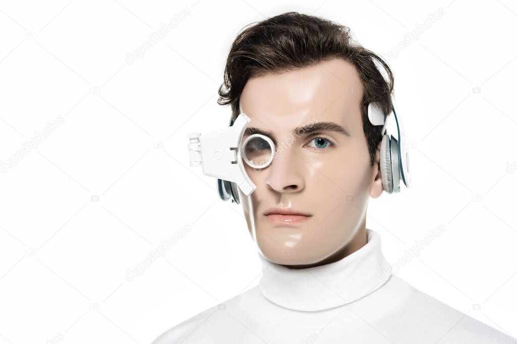 Brunette cyborg man in headphones and eye lens looking at camera isolated on white