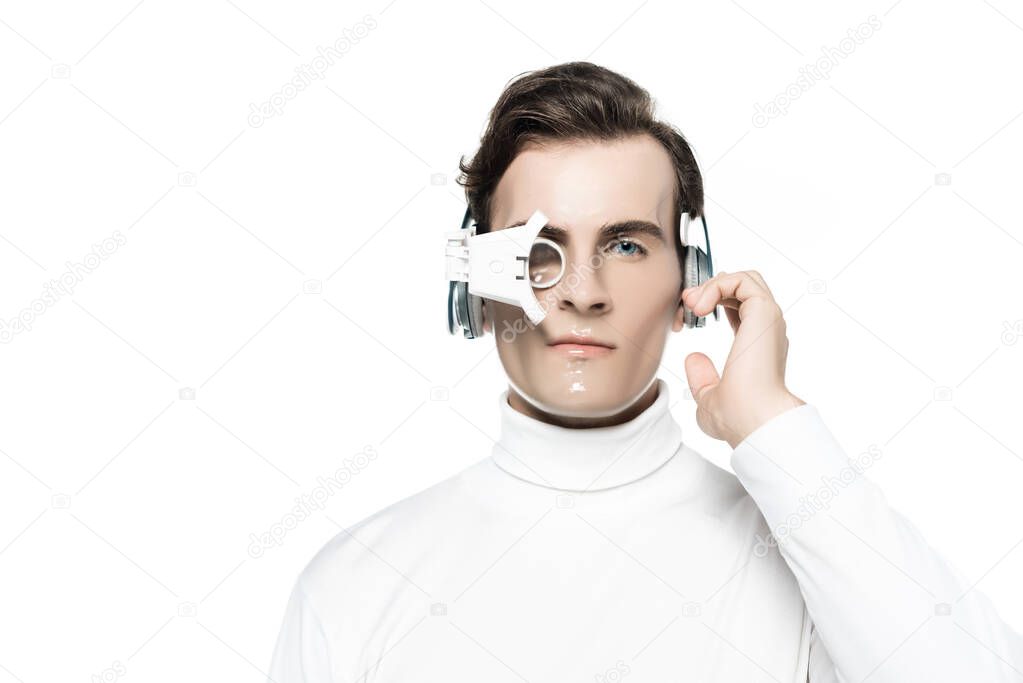 Cyborg in digital eye lens touching headphones and looking at camera isolated on white
