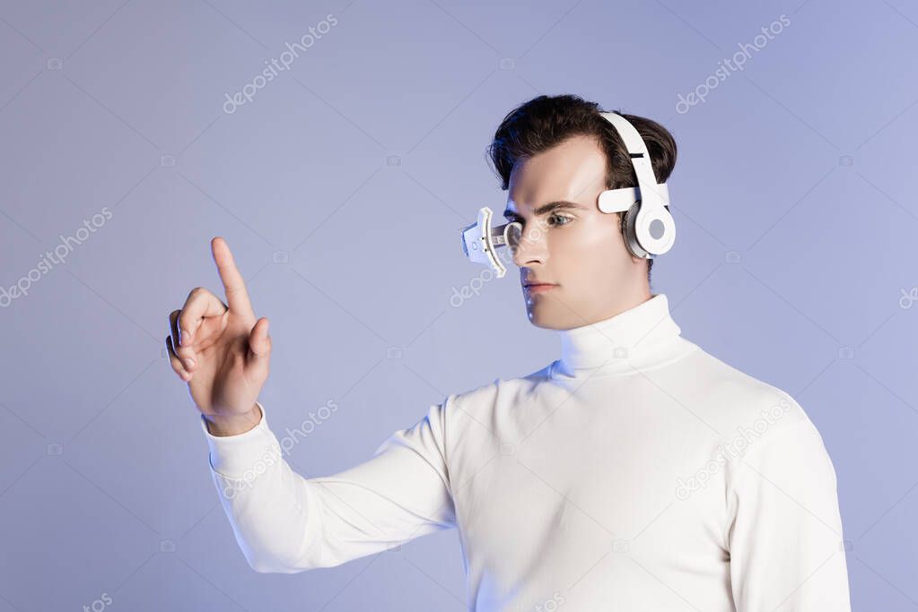 Cyborg in eye lens and headphones touching something isolated on purple