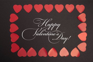 top view of happy valentines day lettering in frame of red hearts on black clipart