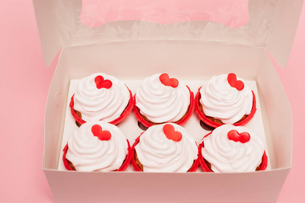 box with valentines cupcakes on pink background