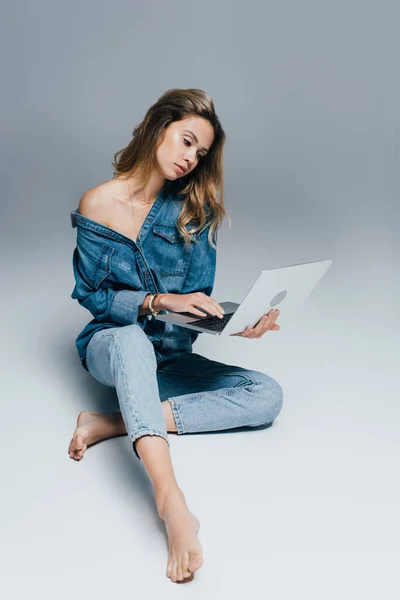 Barefoot Woman Denim Shirt Jeans Using Laptop While Sitting Grey — Stock Photo, Image