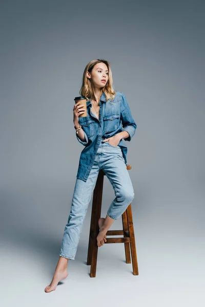 Stylish Woman Denim Clothes Sitting High Chair Disposable Cup Grey — Stock Photo, Image