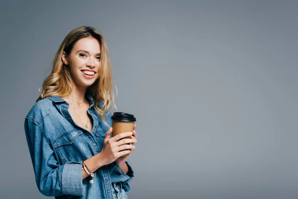 Wesoła Kobieta Dżinsowej Koszuli Trzymająca Kawę Wynos Uśmiechnięta Kamery Odizolowana — Zdjęcie stockowe