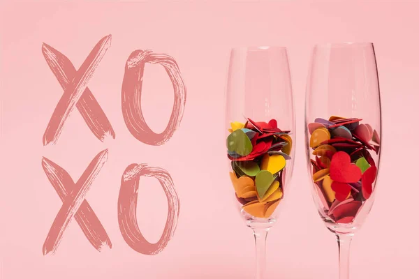 香槟酒杯中色彩艳丽的红心 靠近Xoxo粉红字 — 图库照片