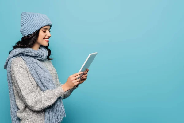 Mujer Morena Sonriente Bufanda Sombrero Mirando Tableta Digital Aislada Azul —  Fotos de Stock