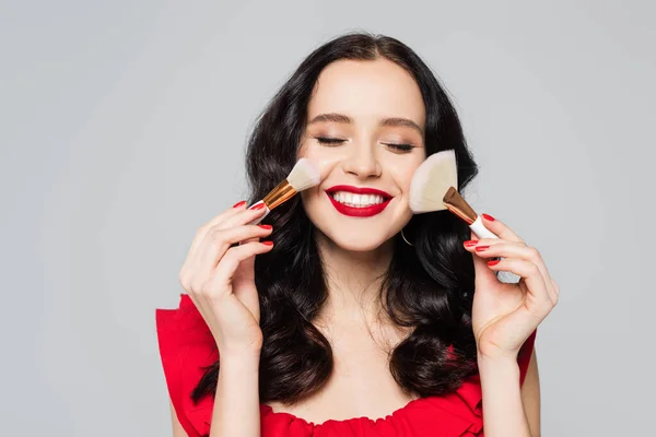 Cheerful Woman Closed Eyes Holding Cosmetic Brushes Isolated Grey — Stock Photo, Image