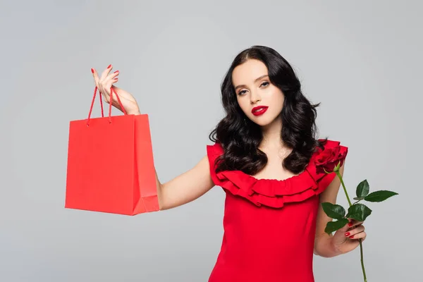 Νεαρή Γυναίκα Κρατώντας Τσάντα Ψώνια Και Τριαντάφυλλο Απομονώνονται Γκρι — Φωτογραφία Αρχείου