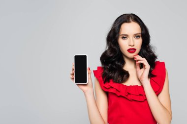 Kırmızı dudaklı kadın gri ekranlı akıllı telefon tutuyor.