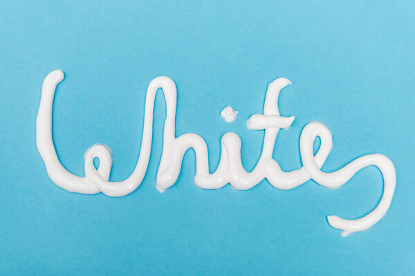 Top view of white lettering from toothpaste on blue background