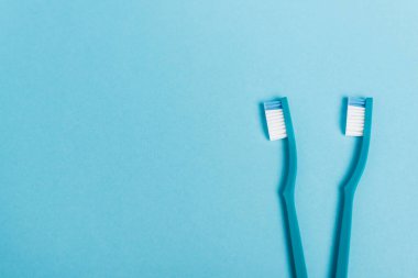 Fotokopi alanı olan mavi arkaplandaki diş fırçalarının üst görünümü 