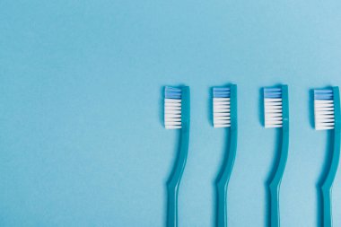 Mavi arkaplanda plastik diş fırçalarının üst görünümü