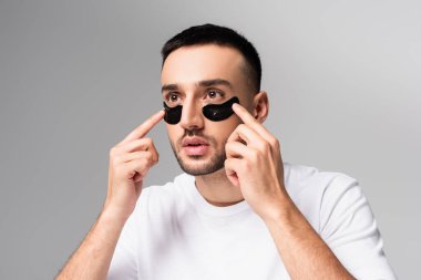 Gri renge göz bandı yapıştıran genç İspanyol adam.