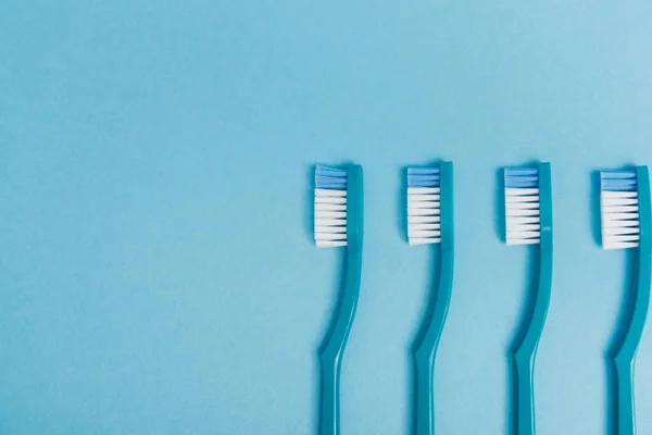Mavi Arkaplanda Plastik Diş Fırçalarının Üst Görünümü — Stok fotoğraf