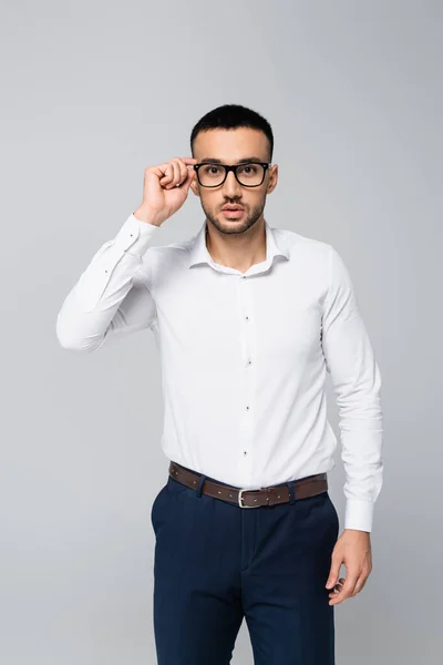Brunette Hispanic Businessman Adjusting Eyeglasses While Looking Camera Isolated Grey — Stock Photo, Image