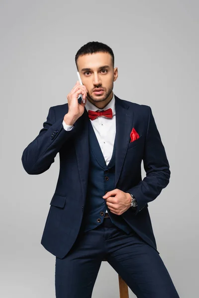 Jonge Spaanse Man Elegant Pak Praten Mobiele Telefoon Geïsoleerd Grijs — Stockfoto