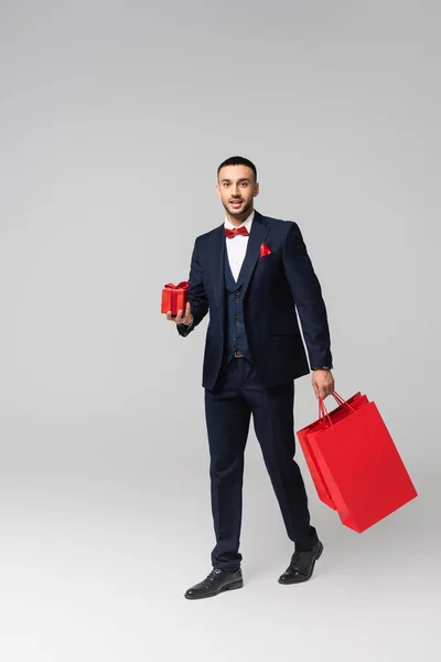 Junger Eleganter Hispanischer Mann Der Mit Roter Geschenkschachtel Und Einkaufstaschen — Stockfoto