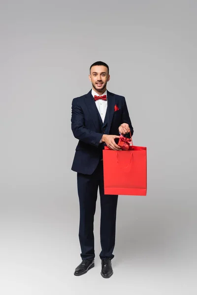 Vista Completa Hombre Hispano Feliz Traje Elegante Poniendo Presente Bolsa — Foto de Stock