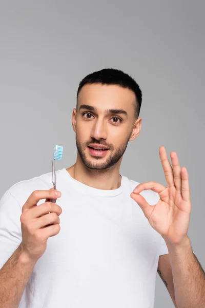 Sorrindo Hispânico Homem Segurando Escova Dentes Enquanto Mostrando Gesto Isolado — Fotografia de Stock