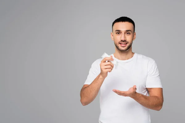 Sonriente Hombre Hispano Camiseta Blanca Sosteniendo Tubo Crema Manos Aislado —  Fotos de Stock