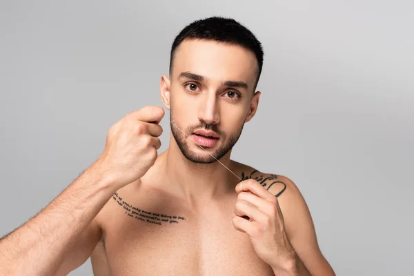 Hombre Tatuado Sin Camisa Hispana Sosteniendo Hilo Dental Aislado Gris —  Fotos de Stock