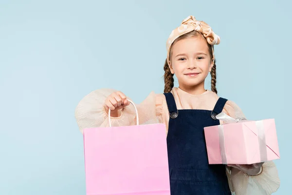 Niño Feliz Con Coletas Sosteniendo Bolsa Compras Presente Aislado Azul — Foto de Stock