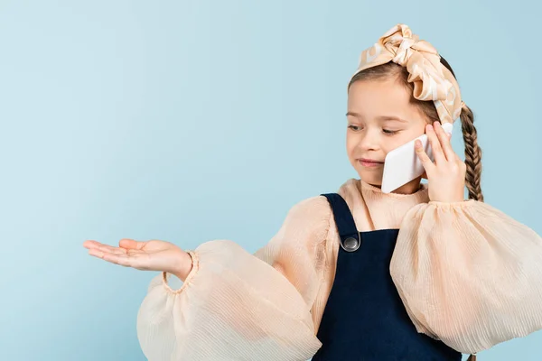 Happy Kid Pigtail Talking Smartphone Pointing Hand Isolated Blue — Stock Photo, Image