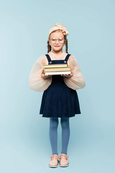 Longitud Completa Niño Inteligente Gafas Sonriendo Mientras Sostiene Libros Azul — Foto de Stock