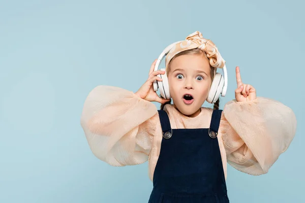 Geschokt Kind Draadloze Hoofdtelefoon Luisteren Muziek Wijzen Met Vinger Geïsoleerd — Stockfoto