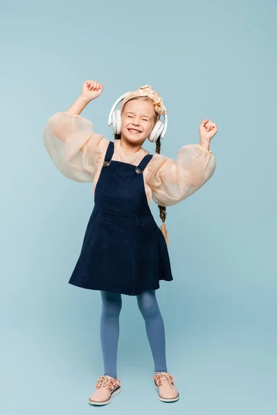 Повна Довжина Усміхненої Дитини Голові Бантом Бездротовими Навушниками Слухаючи Музику — стокове фото