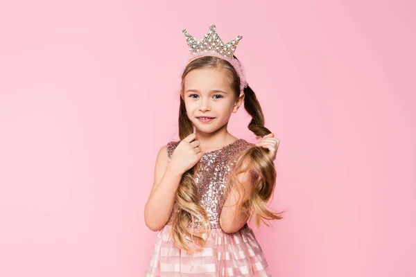 Menina Alegre Vestido Coroa Ajustando Cabelo Isolado Rosa — Fotografia de Stock