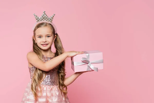 快乐的小女孩 头戴皇冠 手里拿着用粉红包裹的礼物 — 图库照片