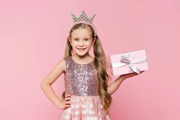 Радісна Маленька Дівчинка Короні Тримає Загорнутий Подарунок Стоїть Рукою Стегні — стокове фото