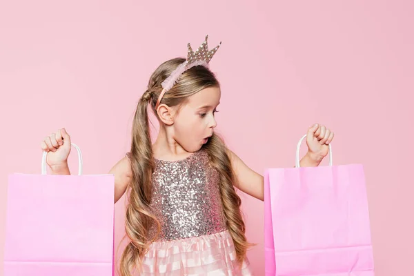 Shocked Little Girl Crown Holding Shopping Bags Isolated Pink — Stock Photo, Image