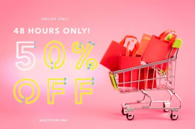 shopping bags in small trolley near online only, 48 hours only, 50 percent off, select styles only lettering on pink, black friday concept clipart