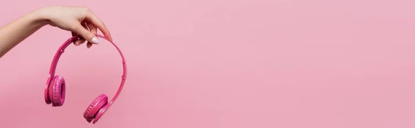 Частичный Вид Женщины Держащей Беспроводные Наушники Изолированы Розовый Баннер — стоковое фото